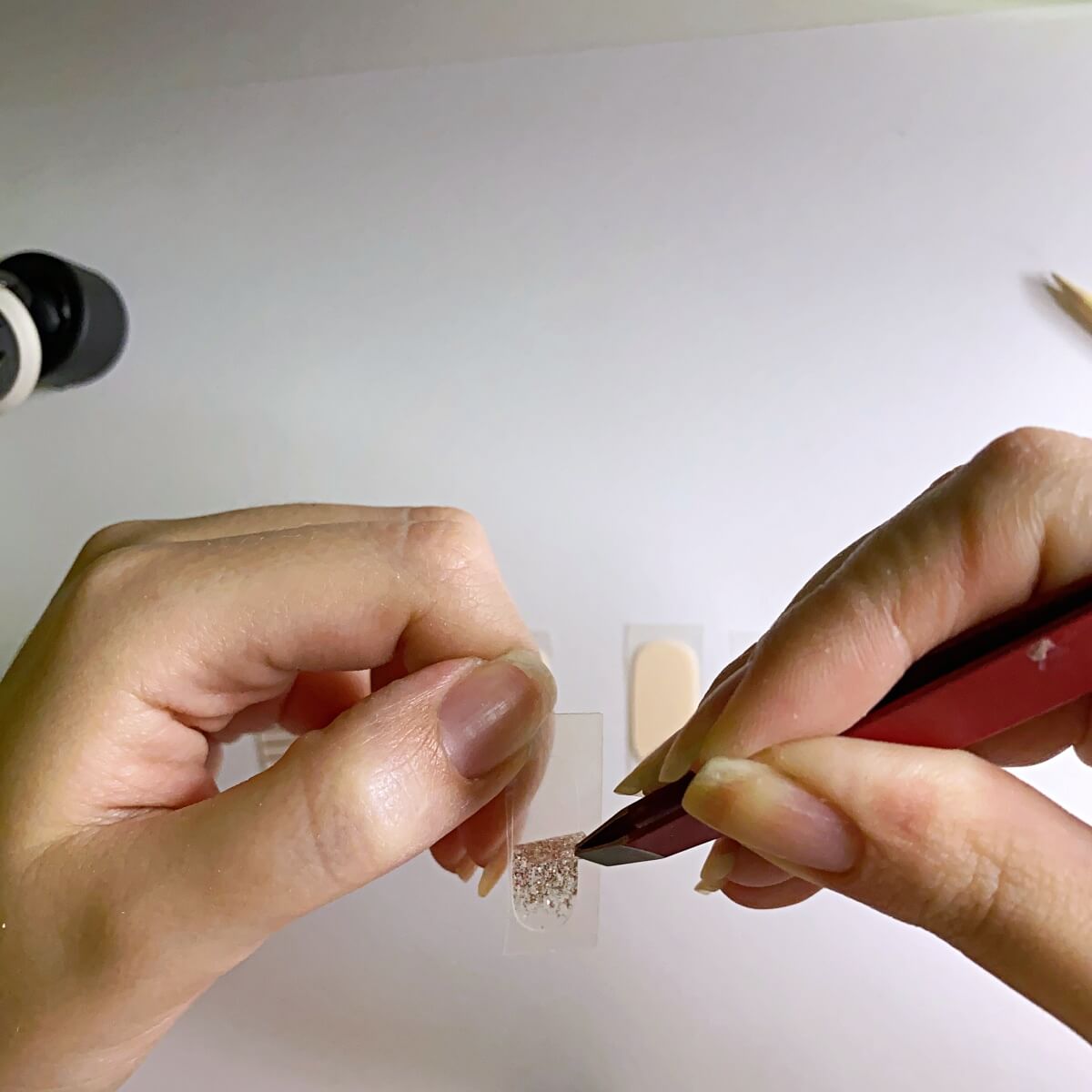 peel nail strips with tweezers