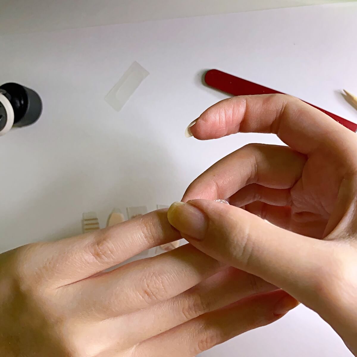 applying dashing diva strips to nails smoothing out air bubbles
