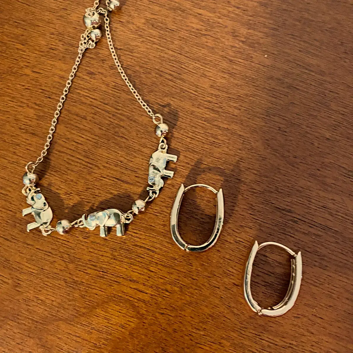gold oval hoop earrings and elephant bracelet