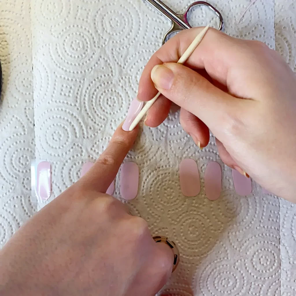 use cuticle pusher to ensure edges of strip are adhered